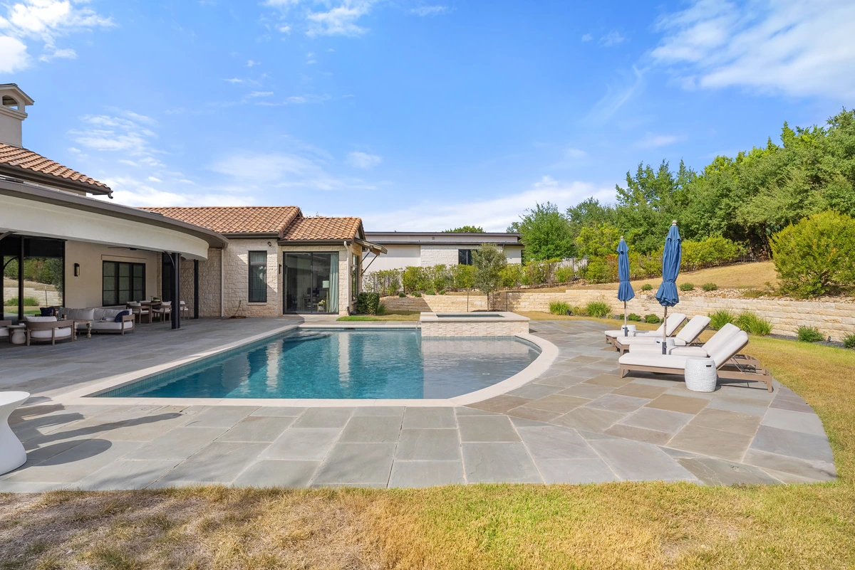 Ground-level view of a serviced backyard pool and patio