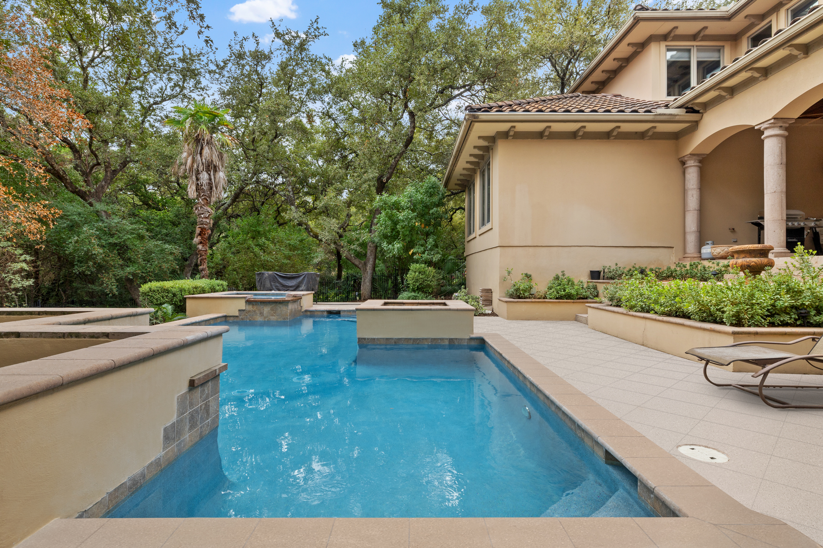 Renovated pool and spa framed by stone columns at a Hill Country estate